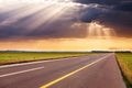 Driving on empty highway towards the sunbeams Royalty Free Stock Photo