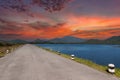Driving on an empty road. Empty asphalt road through the green field and clouds on sunset sky in summer day Royalty Free Stock Photo