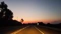 Driving on empty road at sunset Royalty Free Stock Photo