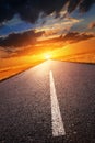 Driving on an empty road towards the setting sun Royalty Free Stock Photo