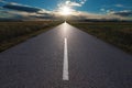 Driving on an empty road towards the setting sun Royalty Free Stock Photo