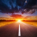 Driving on an empty road towards the setting sun Royalty Free Stock Photo