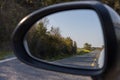 Driving on the forest rural road, view from car mirror Royalty Free Stock Photo