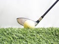 Driving the golf ball with the driver on artificial grass and white background Royalty Free Stock Photo