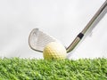 Driving the golf ball with the iron on artificial grass and white background Royalty Free Stock Photo