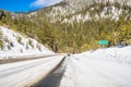 Driving on an ice and snow covered road through the Sierra mountains on a sunny day; Carson City road sign on the right; Nevada Royalty Free Stock Photo