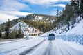 Driving on an ice and snow covered road through the Sierra mountains on a sunny day, Nevada Royalty Free Stock Photo