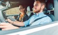 Driving instructor with student in car teaching how to drive Royalty Free Stock Photo