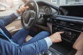 Driving with music. Cropped image of businessman in formal wear pushing buttons of music player while driving to a Royalty Free Stock Photo