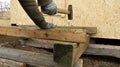 driving a nail into wood at a rustic construction site