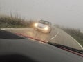 Driving by narrow mountain curvy road a rainy and foggy day Royalty Free Stock Photo