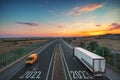Driving on open road toward new year 2023 at sunset. Aerial view of highway, driving car, van and truck. Transportation, logistic Royalty Free Stock Photo