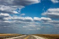 Driving on the rolling hills of Northeastern Oklahoma under a big blue sky with fluffy clouds and rain on the horizon Royalty Free Stock Photo