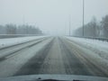 Driving in a storm. Poor visibility through the driver\'s glass onto the road covered with snow and ice. Extreme weather in Royalty Free Stock Photo