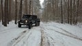 Driving SUV 6x6 by the off-road in the winter forest