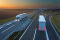 Driving trucks in motion blur on the highway at sunset Royalty Free Stock Photo