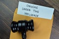 Driving Under The Influence text on document with gavel above brown envelope