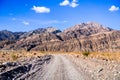 Driving on an unpaved road towards the entrance to Titus Canyon, Death Valley National Park; steep mountains in the background; Royalty Free Stock Photo