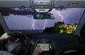 Driving while using navigation system towards lightning over the sea Royalty Free Stock Photo