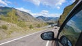 Driving view from side of car mirror mountain valley. Beautiful landscape of a road in the mountains on a sunny day Royalty Free Stock Photo