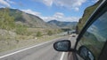 Driving view from side of car mirror mountain valley. Beautiful landscape of a road in the mountains on a sunny day with Royalty Free Stock Photo