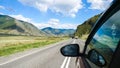 Driving view from side of car mirror mountain valley. Gorgeous landscape of a road in the mountains on a sunny day Royalty Free Stock Photo