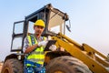 Driving worker heavy wheeled tractor, Workers drive orders through the iPad, Wheel loader Excavator with backhoe unloading sand Royalty Free Stock Photo