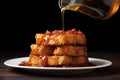 drizzling maple syrup over a stack of french toast
