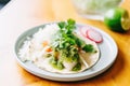 drizzling salsa verde on a fish taco, lime aside