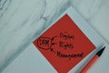 DRM - Digital Rights Management write on sticky note isolated on Wooden Table