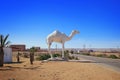 Dromedary camel white statue near a road