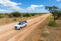 Drone image of offroad vehicle driving on dirt road in African bush