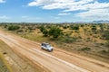 Drone image of offroad vehicle driving on dirt road in African bush