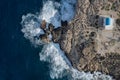 Drone aerial photograph stormy windy waves crashing on a rocky coast .