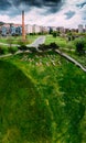 Drone aerial vertical panoramic view of Etxebarria park in Bilbao with trees, lawn, buildings and the old chimney of a