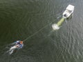 A drone aerial view of children being towed by a power boat on a local dam