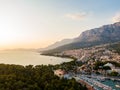 Drone aerial view of Makarska city, Croatia. Sunset over the city, beach and se. Biokovo mountains in the background. Summer time Royalty Free Stock Photo