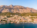 Drone aerial view of Makarska city, Croatia. Sunset over the city, beach and se. Biokovo mountains in the background. Summer time Royalty Free Stock Photo