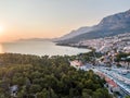 Drone aerial view of Makarska city, Croatia. Sunset over the city, beach and se. Biokovo mountains in the background. Summer time Royalty Free Stock Photo