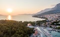 Drone aerial view of Makarska city, Croatia. Sunset over the city, beach and se. Biokovo mountains in the background. Summer time Royalty Free Stock Photo