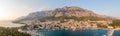 Drone aerial view of Makarska city, Croatia. Sunset over the city, beach and se. Biokovo mountains in the background. Summer time Royalty Free Stock Photo