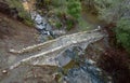 Drone aerial view of a medieval stoned bridge water flowing in the river in autumn.