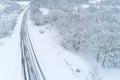drone aerial view of a road in a snow-covered landscape, concept of winter time transportation Royalty Free Stock Photo