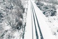 overhead drone aerial view of a road in a snowy landscape, winter time transportation concept Royalty Free Stock Photo