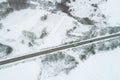 Drone aerial view of three vehicles in a road in a snowy landscape, winter transportation concept Royalty Free Stock Photo