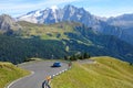DRONE: Blue rally car drives towards a sharp turn in beautiful sunny Dolomites.