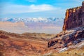 DRONE: Breathtaking flying view snowy mountain range behind a red rocky cliff. Royalty Free Stock Photo