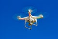 Drone with camera flying with blue sky in the background Royalty Free Stock Photo