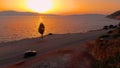 DRONE: Car drives down empty road leading along the cliff and calm sea at sunset Royalty Free Stock Photo