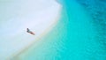 DRONE: Carefree girl sunbathing on pristine white sand beach on One Foot Island. Royalty Free Stock Photo